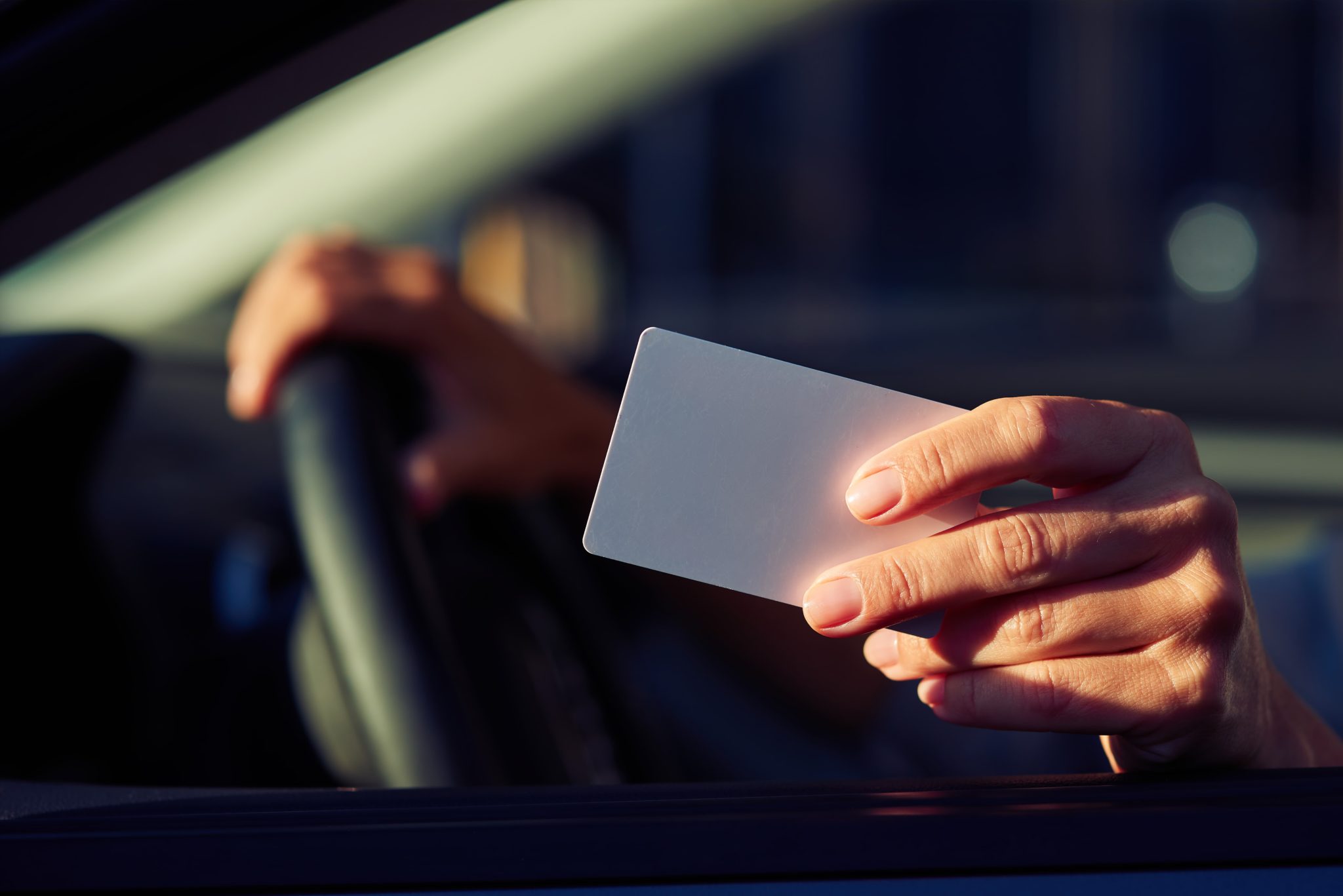 main qui tient une carte et un volant de conduite